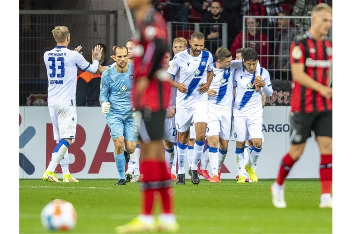 Die Karlsruher Spieler jubeln nach dem Tor zum 1:2. Foto: David Inderlied/dpa