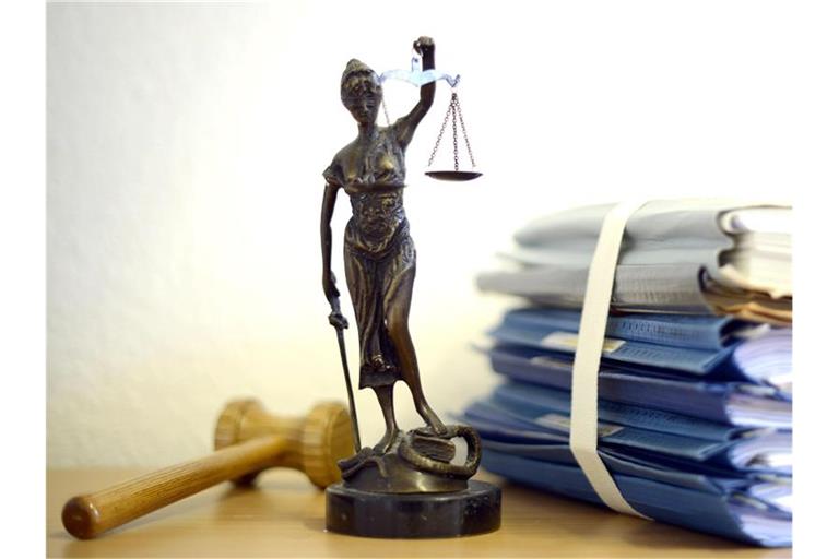 Die modellhafte Nachbildung der Justitia steht auf dem Tisch eines Richters. Foto: Volker Hartmann/Archiv