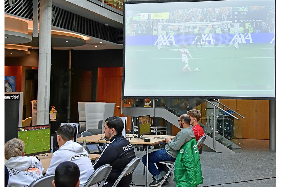 Die pausierenden Teams und die Zuschauer können die Spiele am rechten Tisch auf ...