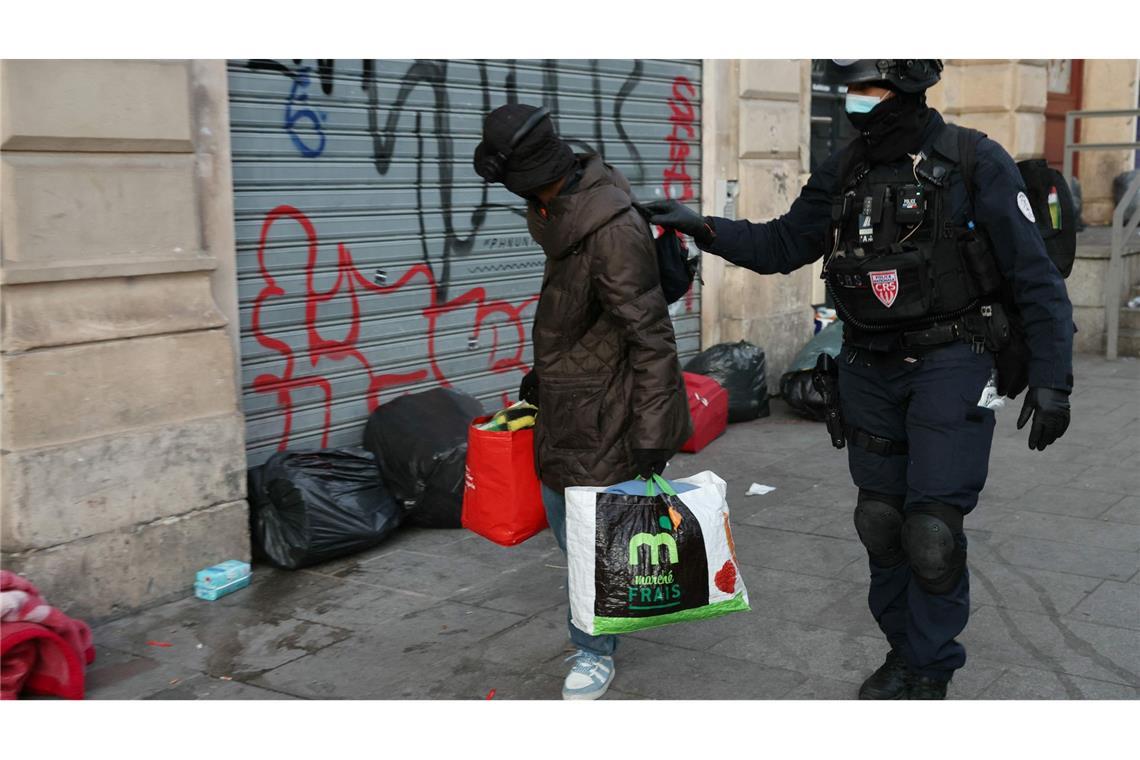 Die Polizei räumt ein von Migranten besetztes Theater in Paris: Ein Polizist begleitet einen Mann aus dem Theater La Gaîté Lyrique - einem Aufführungssaal, der drei Monate lang von rund 450 jungen Migranten besetzt war.