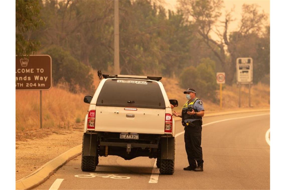 Buschbrand in Westaustralien zerstört Dutzende Häuser Die Polizei spricht bei einer Straßensperre auf der Great Northern Autobahn mit Anwohnern, die versuchen, in ihre Häuser zurückzukehren. Foto: Richard Wainwright/AAP/dpa