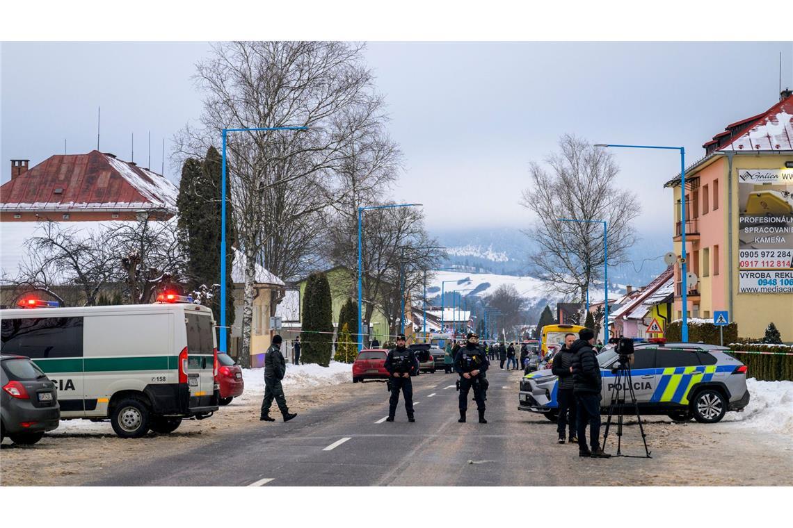 Die Polizei steht auf der Straße zum Gymnasium in dem ein Amoklauf stattfand. Mit einem Messer hat ein 18 Jahre alter Schüler in einem Gymnasium in der Slowakei mindestens zwei Menschen getötet und mehrere verletzt.