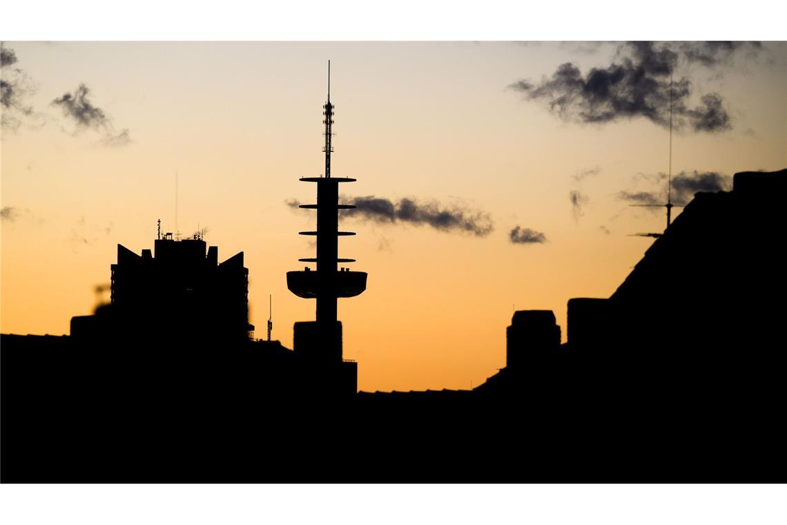 Die Silhouette des „Telemoritz“ - ehemaliger VW-Tower - zeichnet sich in Hannover vor dem vom Sonnenaufgang verfärbten Morgenhimmel ab.