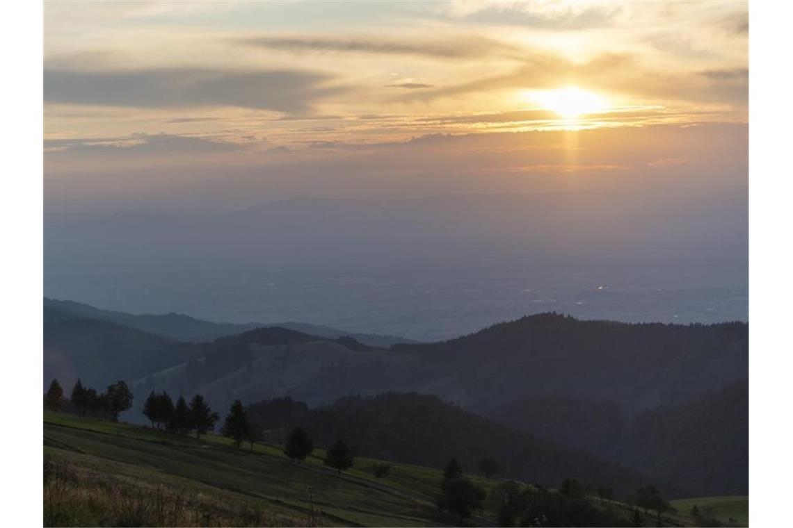 Warme Temperaturen zum Wochenbeginn im Südwesten Die Sonne geht auf dem Schauinsland vor den Vorgesen unter. Foto: Patrick Seeger/Archivbild