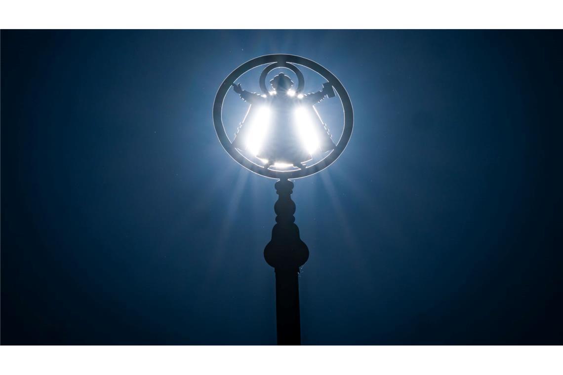 Die Sonne leuchtet hinter dem Münchner Kindl, das auf einem Mast am Odoensplatz im Herzen der bayerischen Landeshauptstadt steht. Die Figur gilt als Wahrzeichen von München.