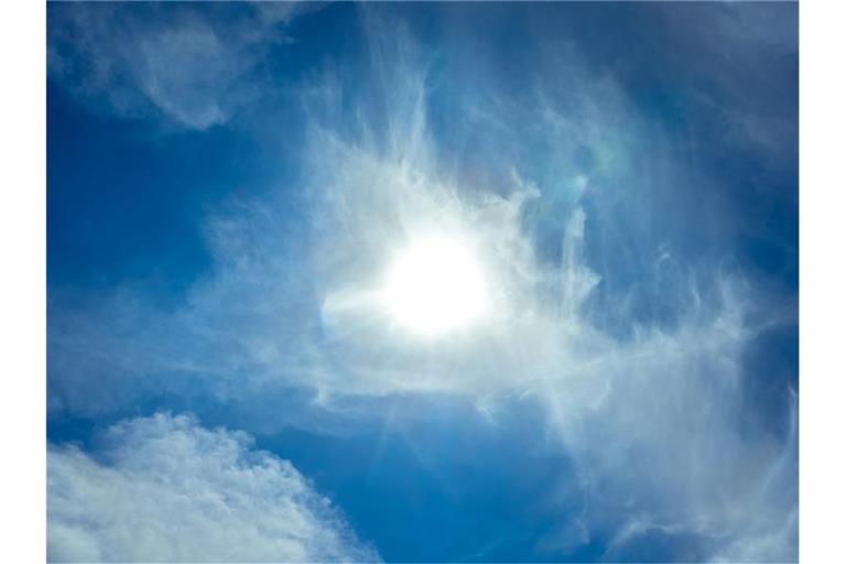 Die Sonne scheint durch leichte Zirrus-Wolken hindurch. Foto: Markus Scholz/dpa/Symbolbild