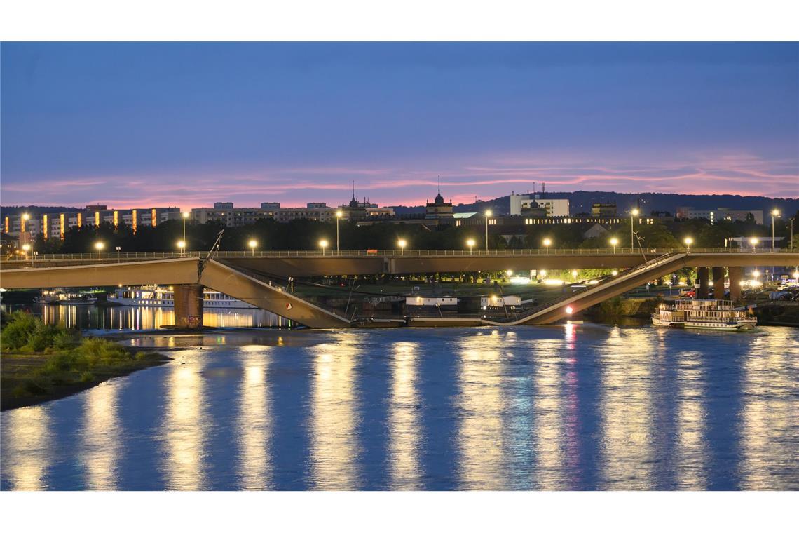 Die Spiegelungen im Wasser der Elbe wirken idyllisch, aber das täuscht über den Ernst der Lage hinweg. Teile der Carolabrücke in Dresden sind in der Nacht eingestürzt. Es ist großes Glück, dass es weder Verletzte noch Tote gab, denn täglich fahren viele Autos, Straßenbahnen und Radfahrer über das Bauwerk.