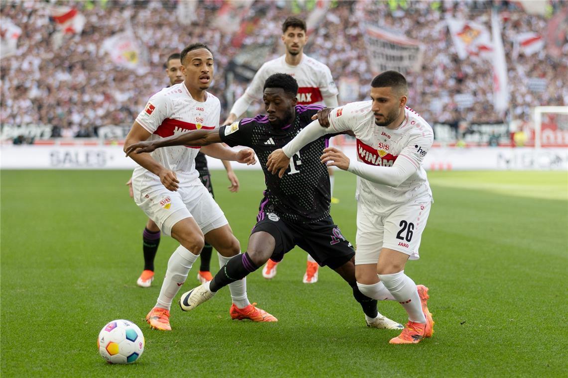 Die Stuttgarter Jamie Leweling (links) und Deniz Undav nehmen den Münchner Alphonso Davies in die Zange. Schnappen sie ihm am Ende auch noch die Vizemeisterschaft weg? 
         
            Foto:  Baumann