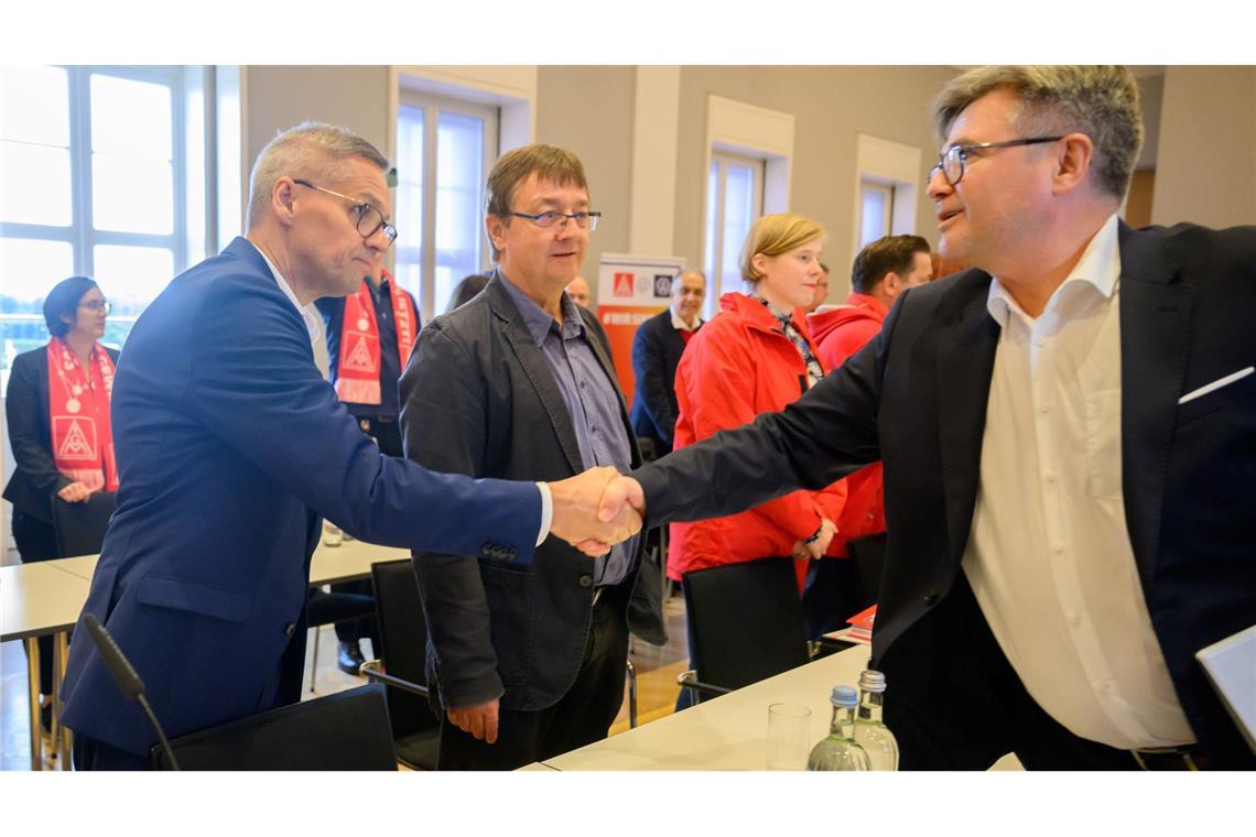 Die Verhandlungsführer Thorsten Gröger (IG Metall, links) und Arne Meiswinkel (Volkswagen, rechts) begrüßen sich im Saal per Handschlag.