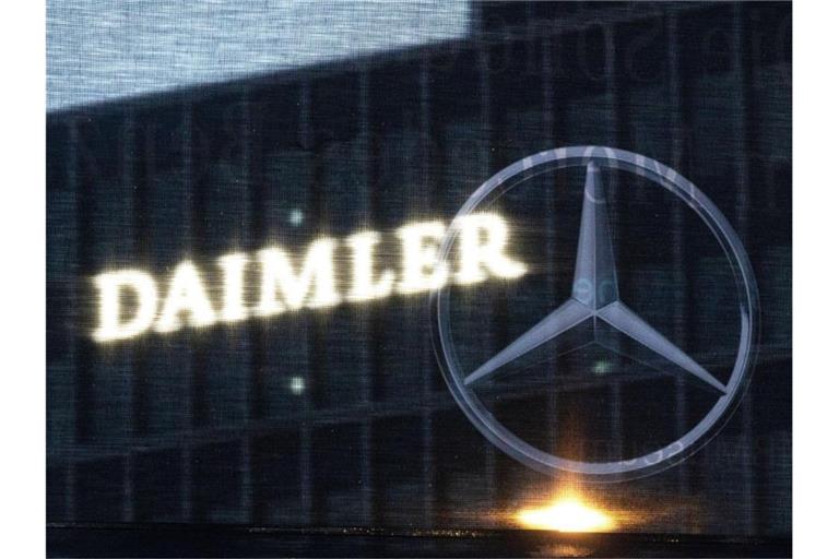 Die Zentrale der Daimler AG ist durch eine Flagge zu sehen, auf der der Mercedes-Stern abgebildet ist. Foto: Marijan Murat/dpa