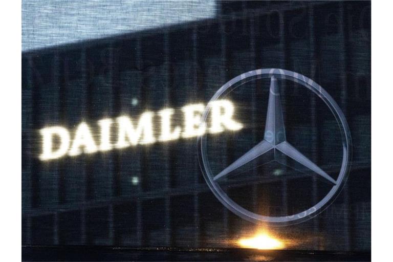 Die Zentrale der Daimler AG ist durch eine Flagge zu sehen, auf der der Mercedes-Stern abgebildet ist. Foto: Marijan Murat/dpa/Symbolbild