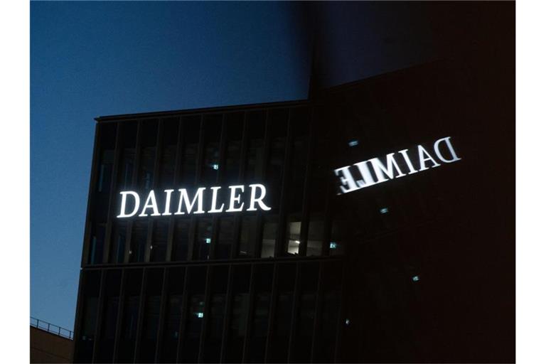 Die Zentrale des Autobauers Daimler spiegelt sich in einem Fenster. Foto: Marijan Murat/dpa/Symbolbild