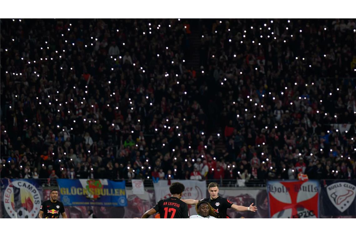 Die Zuschauer im Stadion lassen in Gedenken an einen gestorbenen Fan die Lichter ihrer Handys leuchten.