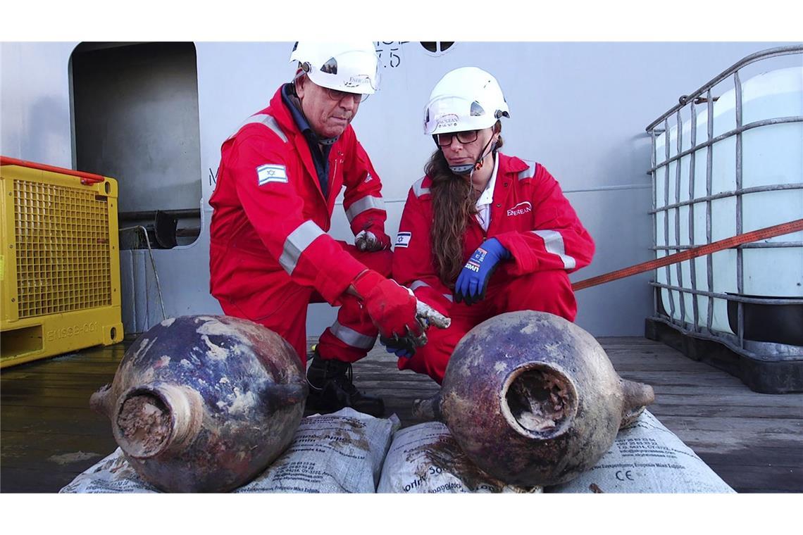 Dieses Foto zeigt die Archäologen Jacob Sharvit (li.) und Karnit Bahartan mit den antiken Gefäßen, die auf dem ältesten bekannten Tiefseeschiff der Welt transportiert wurden, das etwa 56 Meilen (90 Kilometer) vor der israelischen Küste liegt.