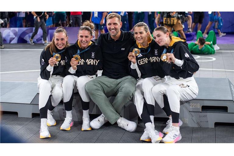 Dirk Nowitzki (Mi.) feiert mit dem 3x3-Basketballerinnen deren Olympiasieg.