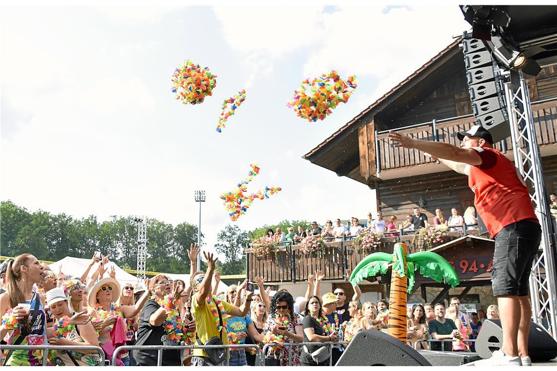 DJ Thommy versorgt das Publikum mit Blumenketten. 