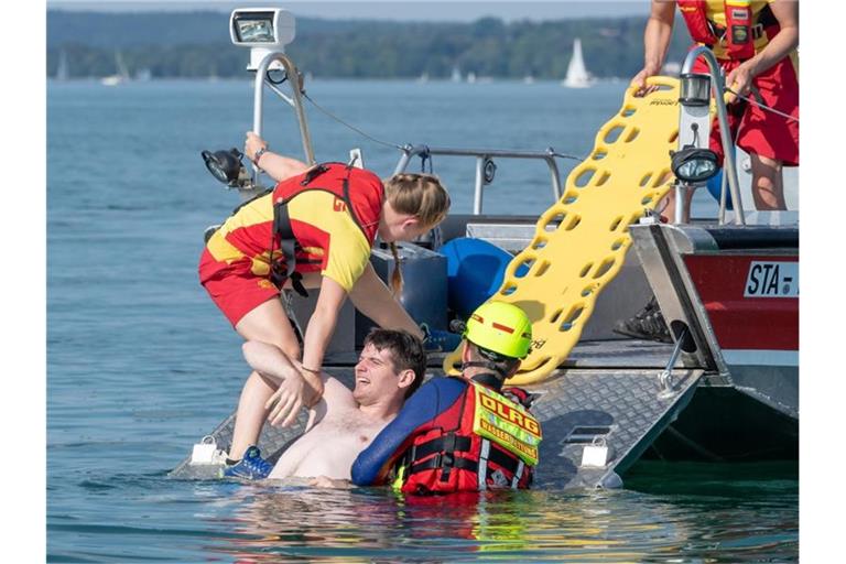 DLRG-Mitglieder nehmen auf einem See mit einem Boot an einer Übung teil. Foto: Peter Kneffel/dpa/Archivbild