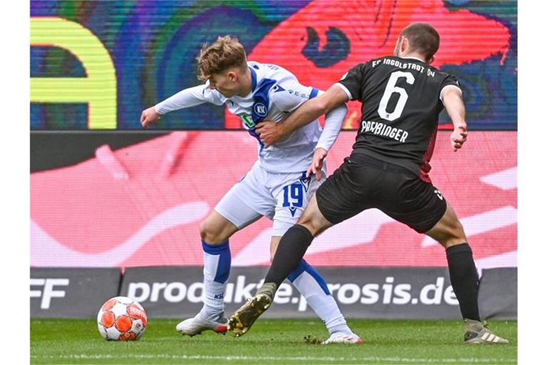 Dominik Kother (l) von Karlsruhe und Rico Preißinger von Ingolstadt kämpfen um den Ball. Foto: Armin Weigel/dpa