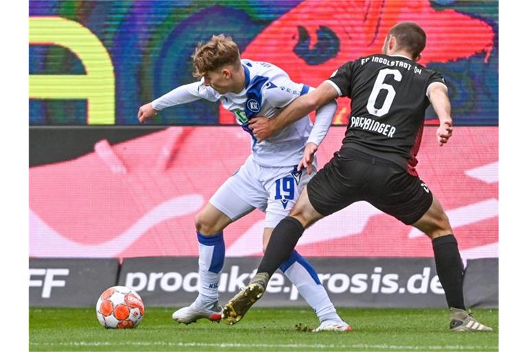 Dominik Kother von Karlsruhe und Rico Preißinger von Ingolstadt kämpfen um den Ball. Foto: Armin Weigel/dpa/Archivbild