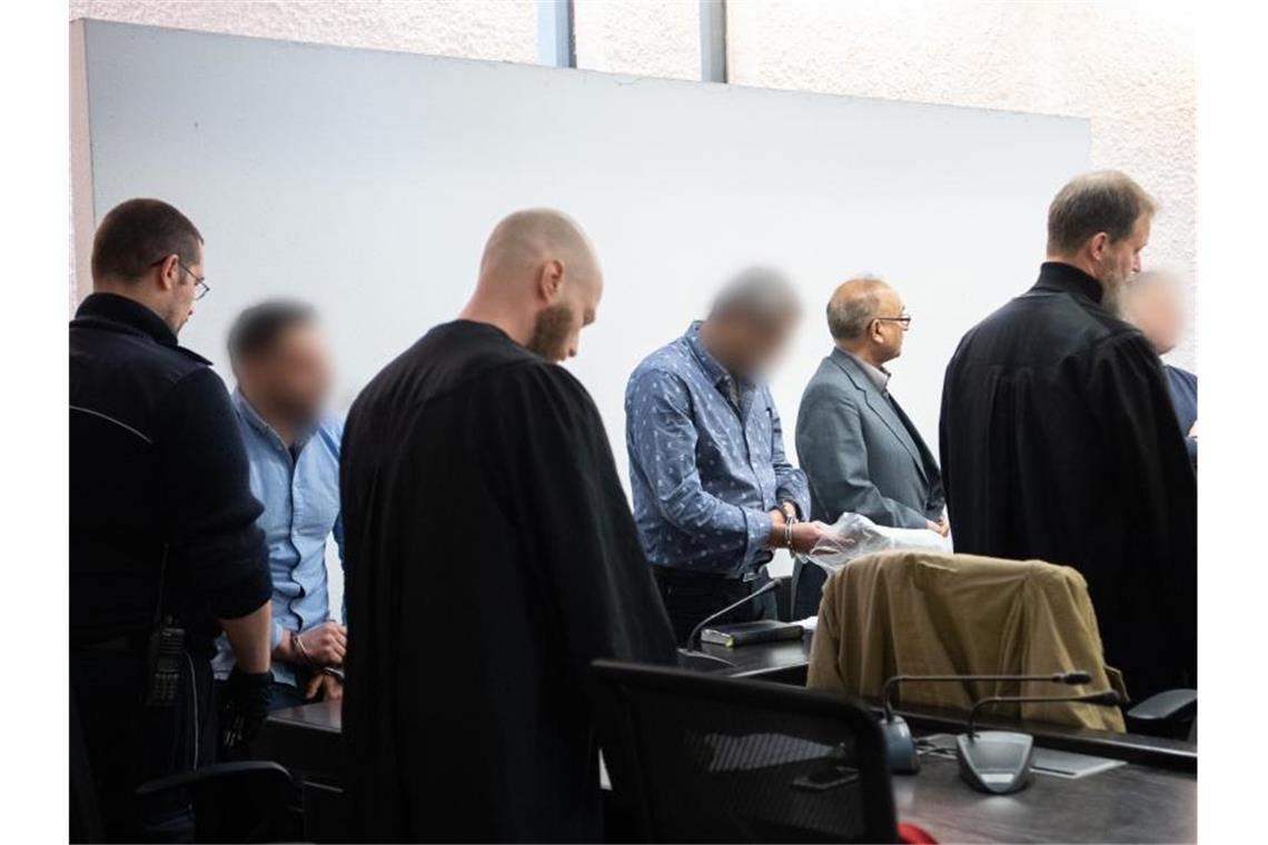 Gericht verurteilt Geldwäscher nach Millionenbetrug Drei Angeklagte vor Urteilsverkündung im Prozess um millionenschwere Geldwäsche neben ihren Anwälten. Foto: Sebastian Gollnow/dpa