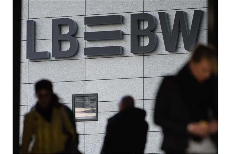 Drei Menschen gehen vor dem Schriftzug der Landesbank Baden-Württemberg (LBBW) entlang. Foto: Sebastian Gollnow/dpa/Archivbild