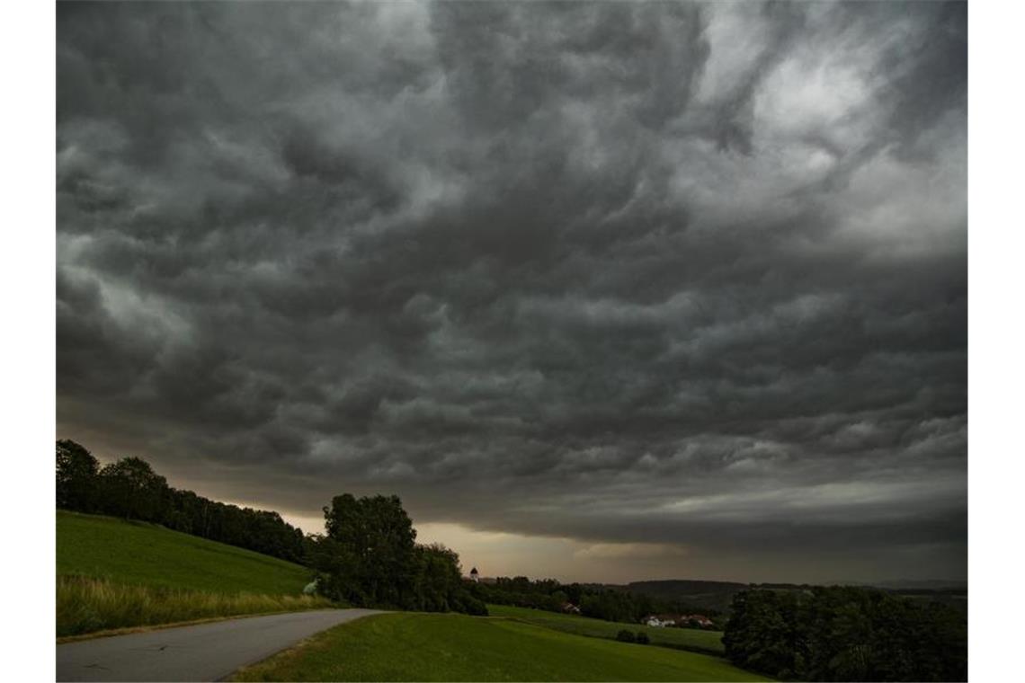 Dunkle Gewitterwolken sind am Nachthimmel über einer Wiese zu sehen. Foto: Tobias Hartl/vifogra/dpa