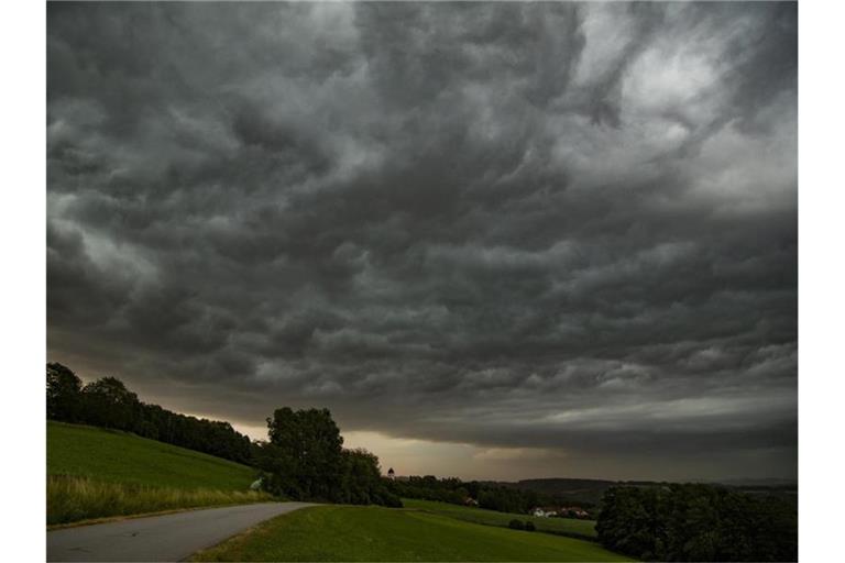 Dunkle Gewitterwolken sind am Nachthimmel über einer Wiese zu sehen. Foto: Tobias Hartl/vifogra/dpa