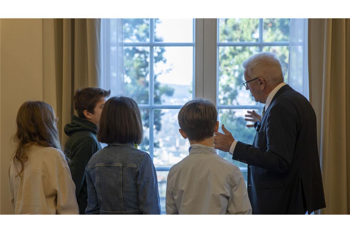 Durch das Fenster zeigt Kretschmann den Kindern die drei beeindruckenden Mammutbäume im Garten.