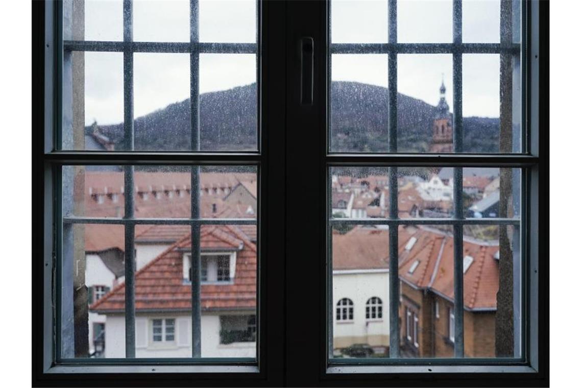 Durch die Fenstergitter in einem Zellentrakt eines Gebäudes des ehemaligen Gefängnisses „Fauler Pelz“ sind Wohnhäuser der Innenstadt zu sehen. Foto: Uwe Anspach/dpa/Produktion