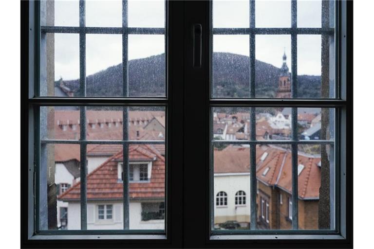 Durch die Fenstergitter in einem Zellentrakt eines Gebäudes des ehemaligen Gefängnisses „Fauler Pelz“ sind Wohnhäuser der Innenstadt zu sehen. Foto: Uwe Anspach/dpa/Produktion