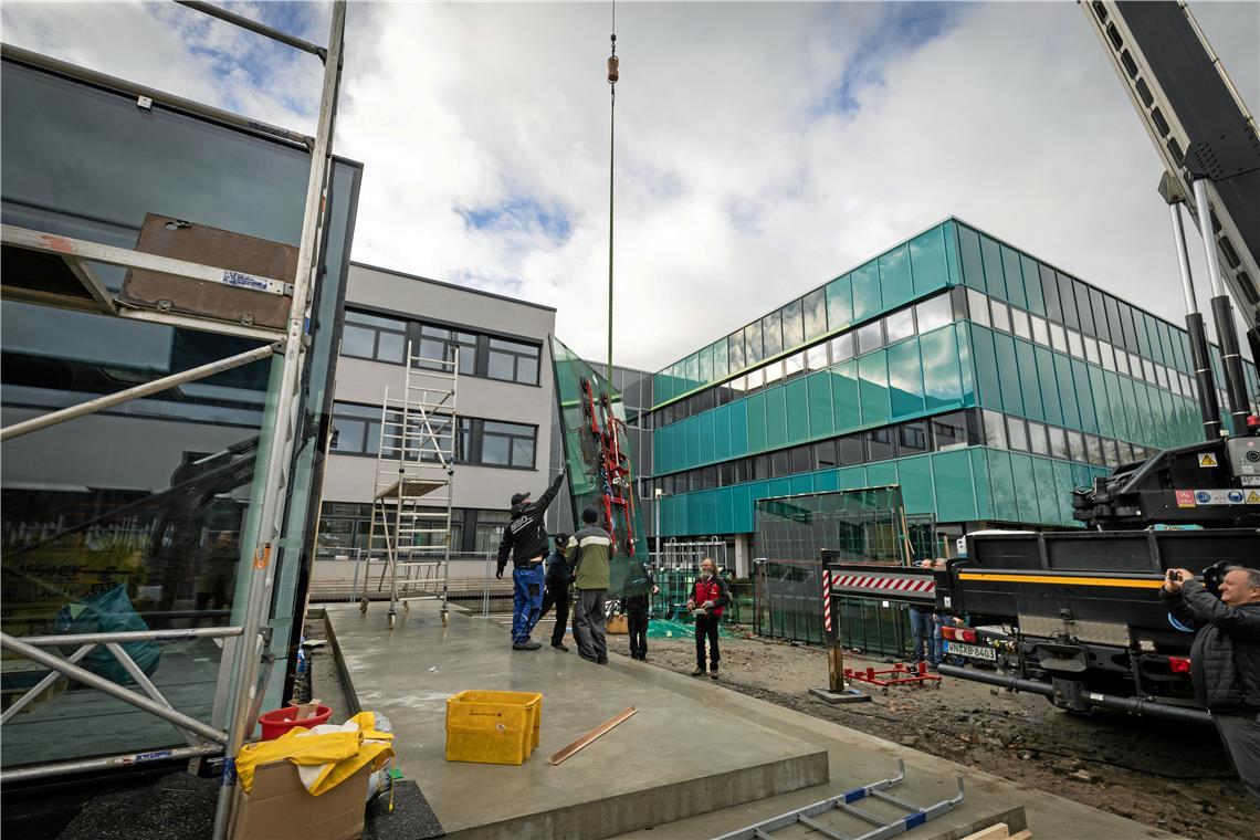 Durch gläserne Wände soll der Showroom die Neugierde Außenstehender wecken. Beim Einbau der jeweils eine Tonne schweren Fenster ist Feingefühl gefragt. Fotos: Alexander Becher