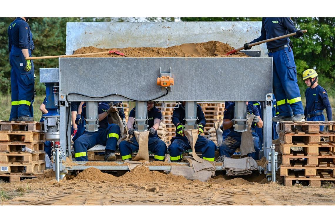 Ehrenamtliche Helfer vom THW füllen in Eisenhüttenstadt Sandsäcke gegen das Hochwasser des Flusses Oder.