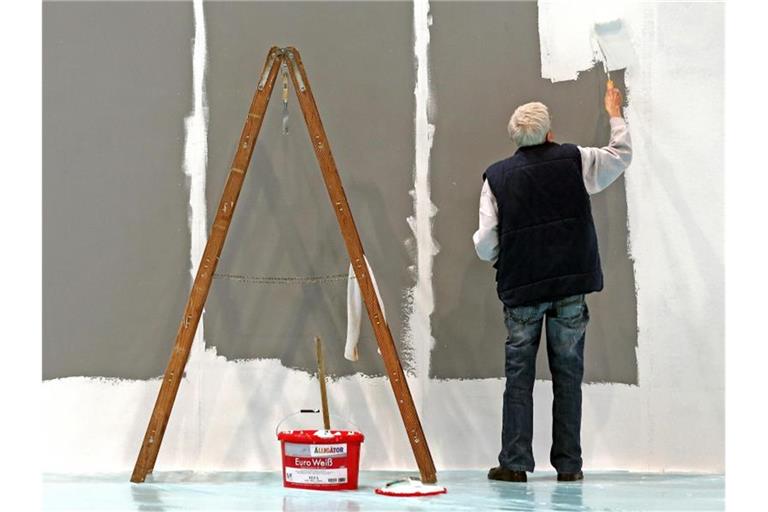 Ein älterer Mann streicht auf der Leipziger Messe eine Wand. Die Menschen in Deutschland beziehen immer länger Rente, zugleich sind sie in den vergangenen Jahren immer später in Rente gegangen. Foto: Jan Woitas/dpa-Zentralbild/dpa