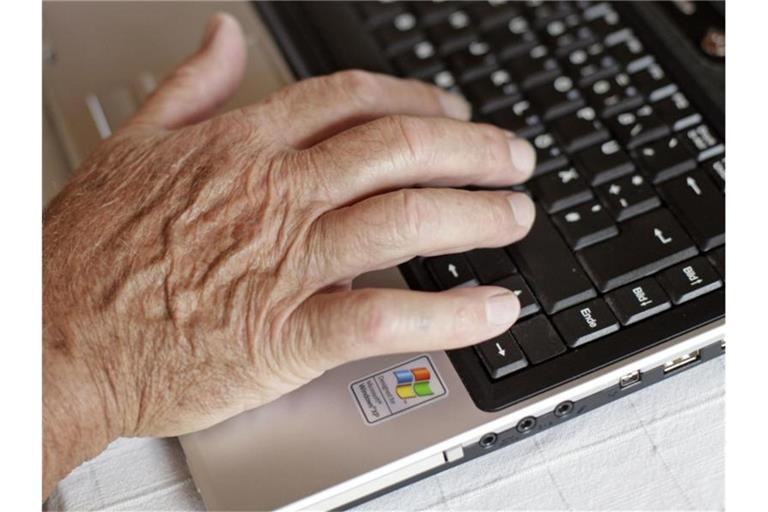 Ein älterer Mann tippt auf seinem Laptop. Foto: picture alliance / dpa/Archivbild