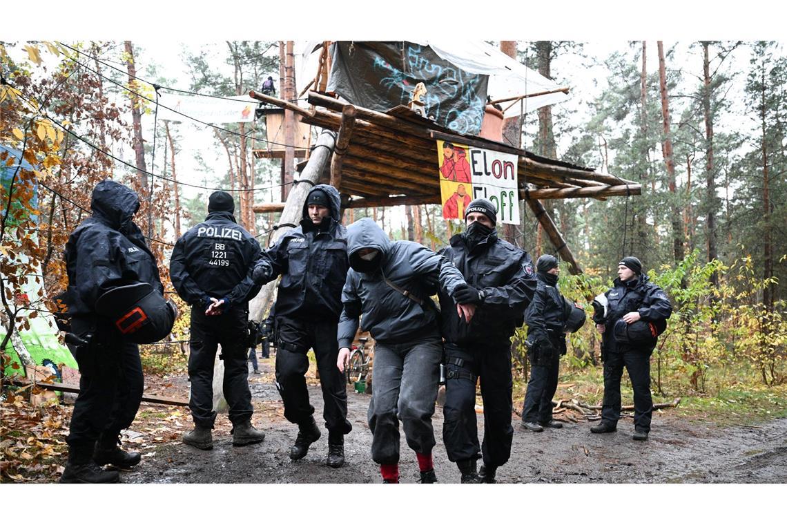 Ein Aktivist wird von Polizisten aus dem Protestcamp in der Nähe des Tesla-Autowerks in Grünheide abgeführt.