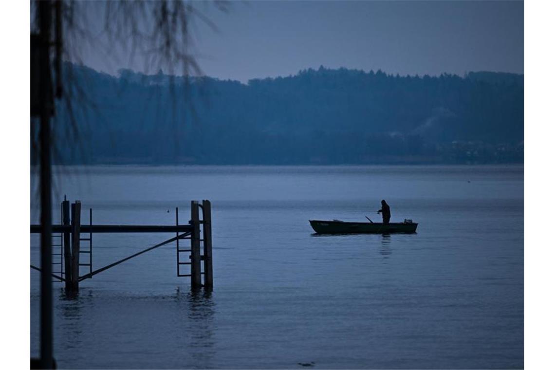 Ein Angler hat seine Rute ausgelegt. Foto: Felix Kästle/dpa