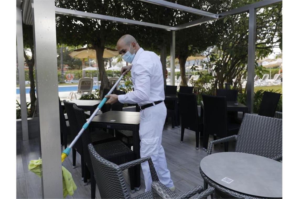 Malle jubelt über deutsche Touristen, viele Spanier meckern Ein Arbeiter reinigt die Terrasse des Hotels Riu Festival in Palma de Mallorca. Foto: Clara Margais/dpa