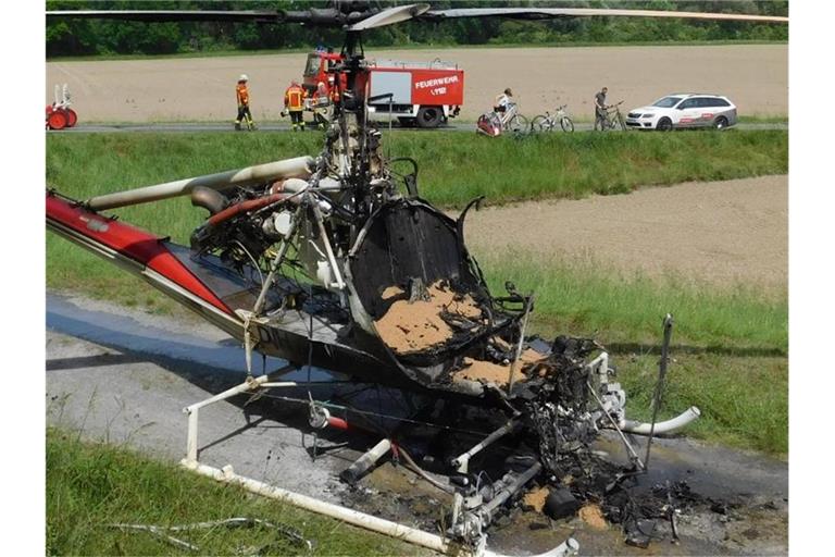 Ein ausgebrannter Hubschrauber steht auf einem Feldweg. Foto: FF Dettenheim/Einsatz-Report24