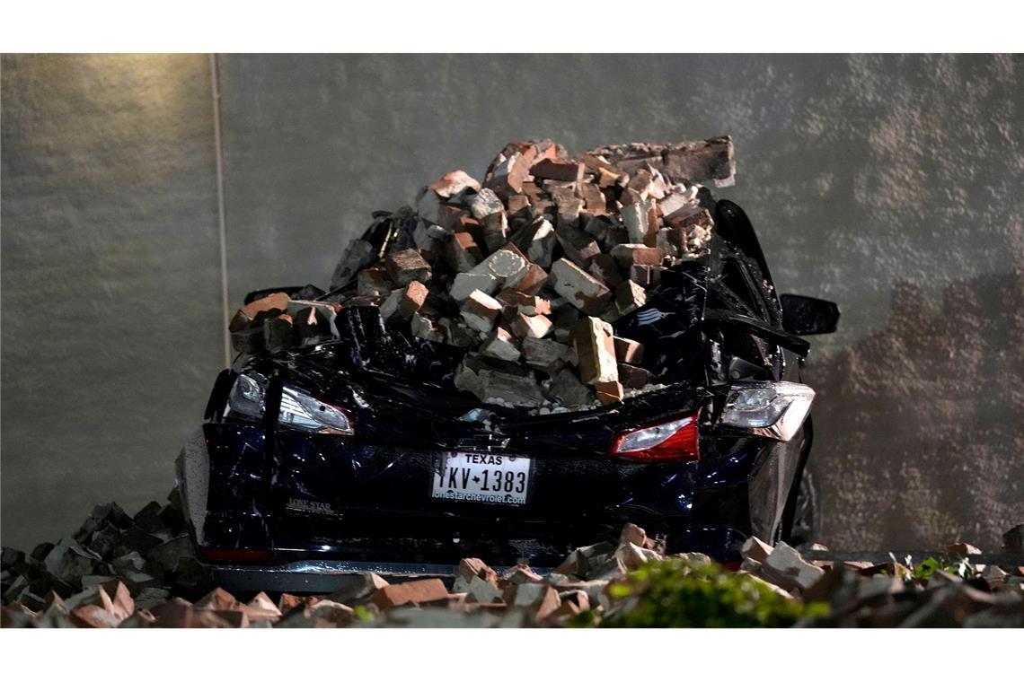 Ein Auto, das von herabfallenden Ziegeln einer umgestürzten Hauswand zerquetscht wurde, steht auf einem Parkplatz in der Innenstadt von Houston.