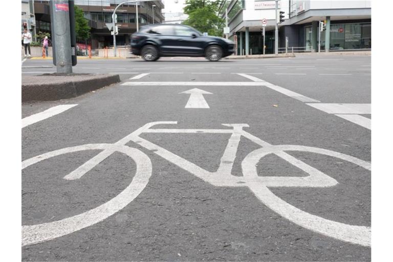 Ein Auto fährt auf der Theodor-Heuss-Straße. Davor ist ein Radweg zu sehen. Foto: Gregor Bauernfeind/dpa/Archivbild