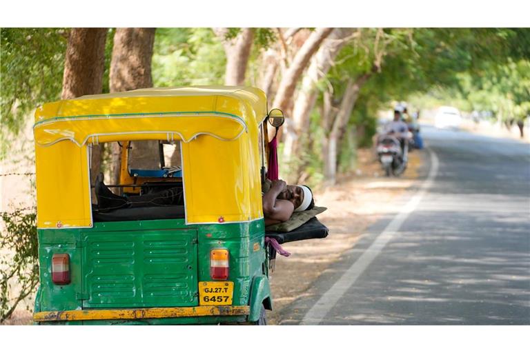 Ein Auto-Rikscha-Fahrer ruht sich an einem heißen Sommertag in seinem Fahrzeug aus, das im Schatten eines Baumes bei der Stadt Ahmedabad geparkt ist. Noch immer ist Indien von einer Hitzewelle betroffen.