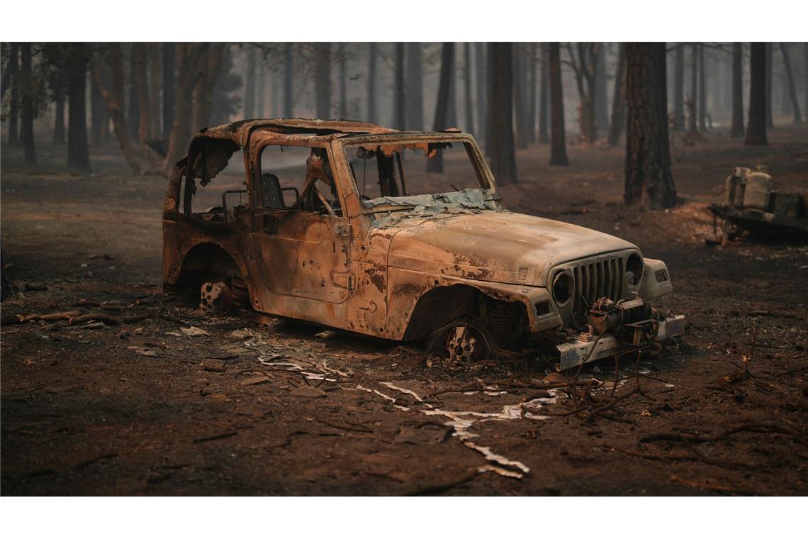 Ein Auto und der umliegende Wald in Wrightwood sind verbrannt, nachdem das "Bridge Fire" durch das Gebiet gezogen ist.