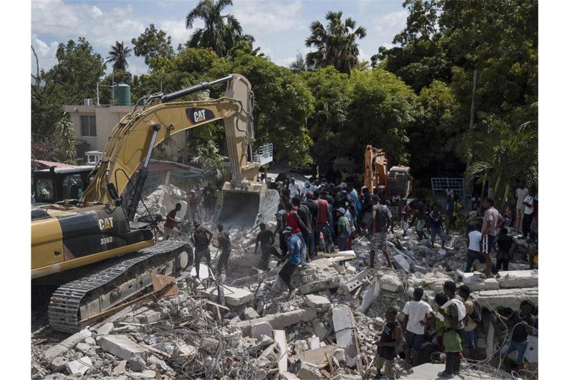 Haiti: Tropensturm setzt Menschen in Erdbebenregion zu Ein Bagger entfernt die Trümmer eines eingestürzten Hotels. Foto: Matias Delacroix/AP/dpa