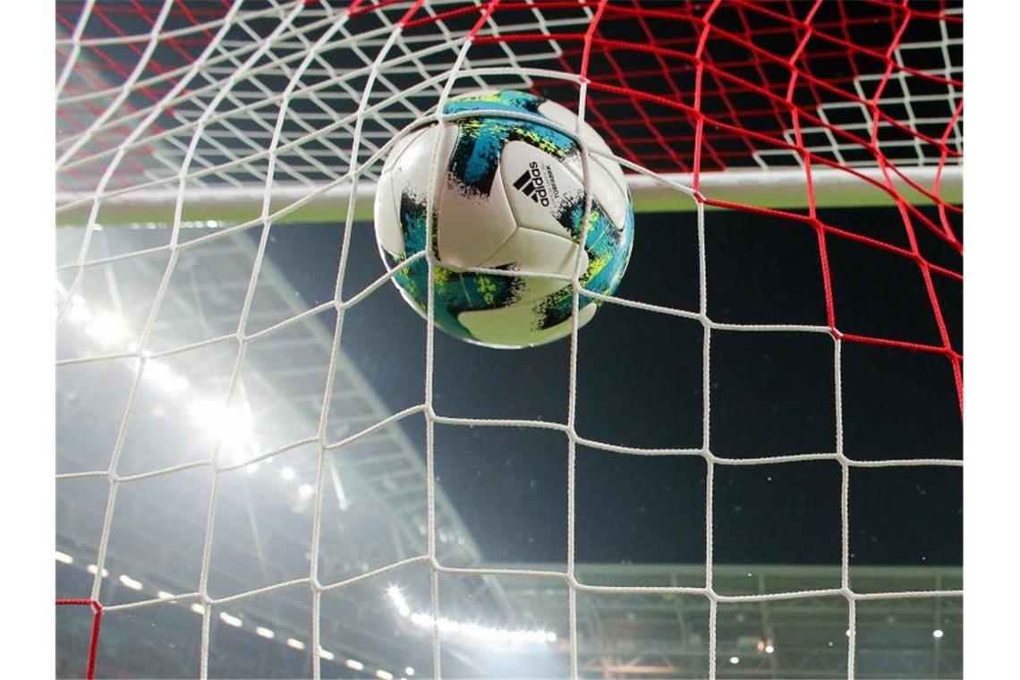 Positiv-Tests und Quarantäne: Geldstrafe für Karlsruher SC Ein Ball geht ins Netz. Foto: Jan Woitas/dpa-Zentralbild/dpa/Symbolbild