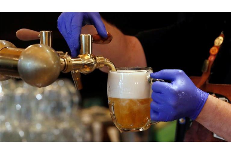 Ein Barkeeper zapft ein Bier auf einer Restaurant-Terrasse. (Symbolbild)