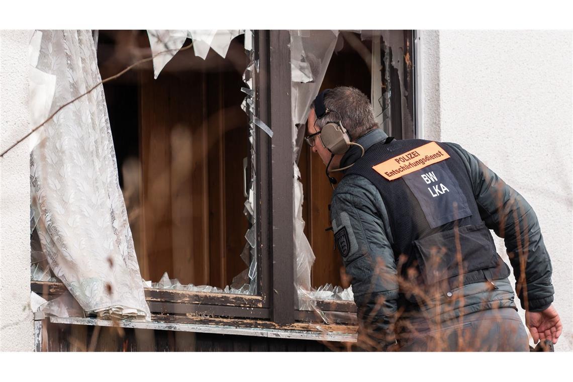 Ein Beamter des Entschärfungsdienstes der Polizei schaut durch ein eingeschlagenes Fenster einer Doppelhaushälfte, in der sich ein Ex-Soldat verschanzt hatte (Archivfoto).