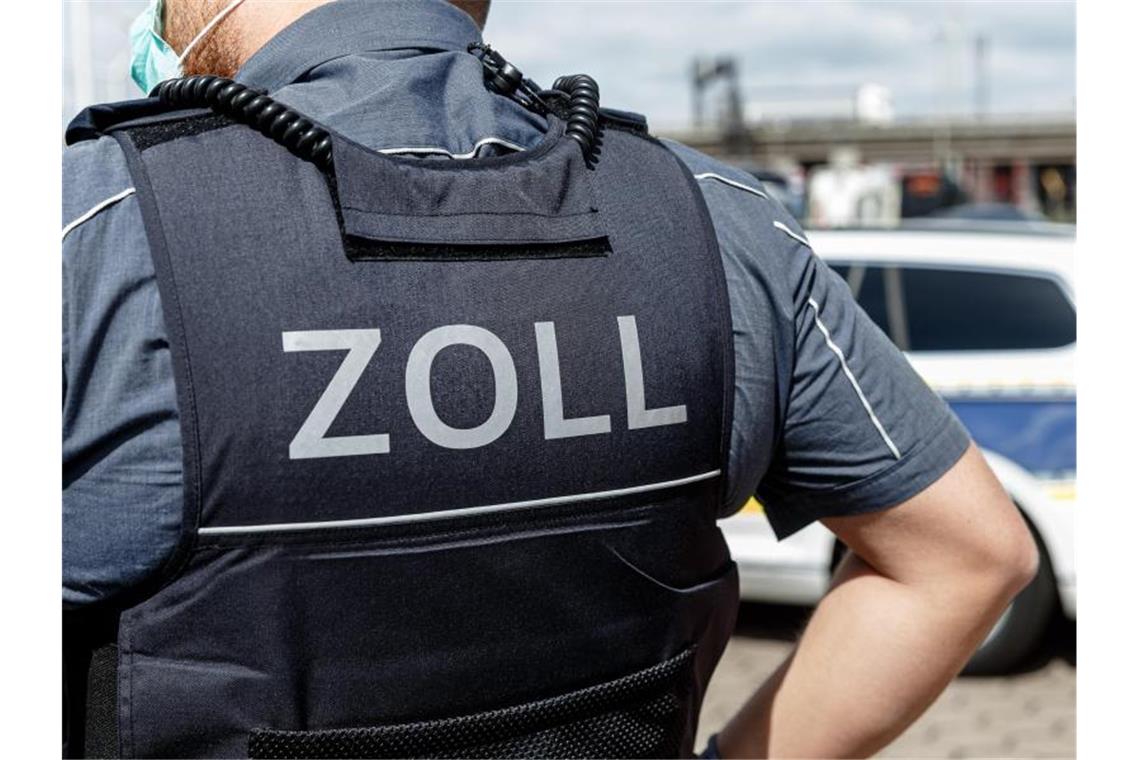 Ein Beamter trägt während seines Dienstes eine Schutzweste mit der Rückenaufschrift "Zoll". Foto: Markus Scholz/dpa/Symbolbild