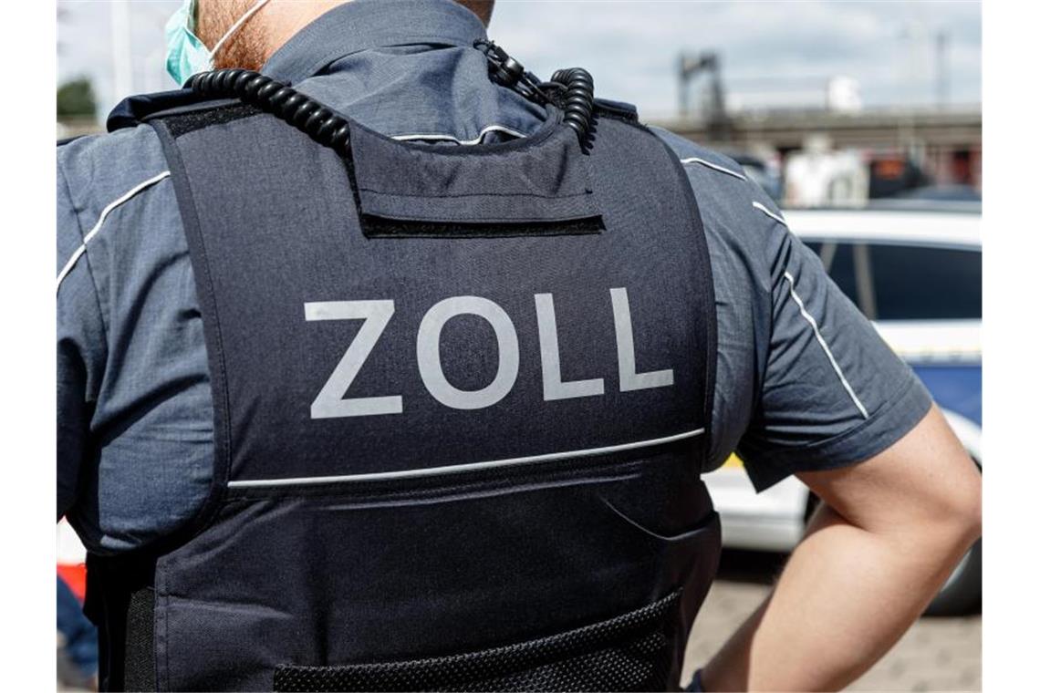 Ein Beamter trägt während seines Dienstes eine Schutzweste mit der Rückenaufschrift "Zoll". Foto: Markus Scholz/dpa/Symbolbild