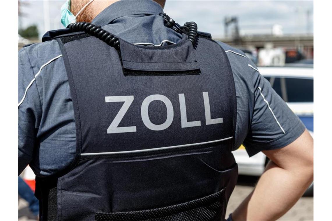 Ein Beamter trägt während seines Dienstes eine Schutzweste mit der Rückenaufschrift "Zoll". Foto: Markus Scholz/dpa/Symbolbild