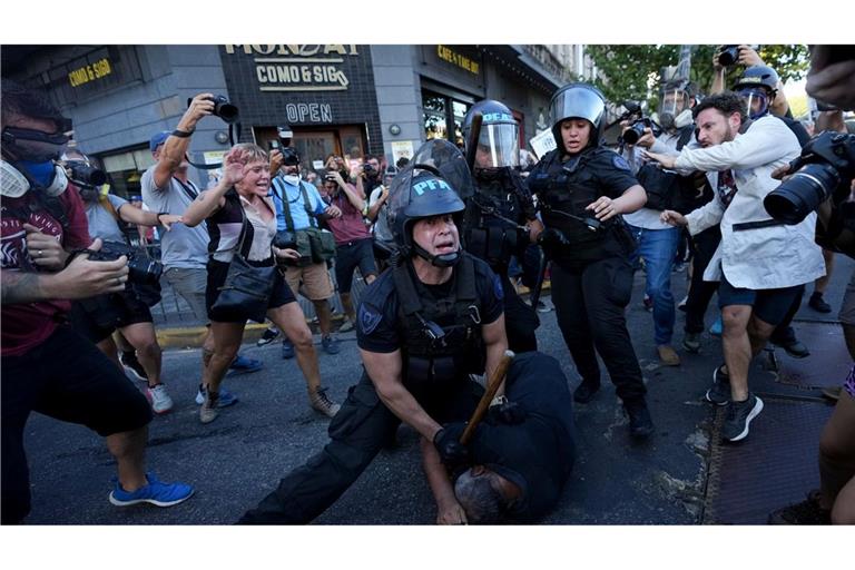 Ein Bereitschaftspolizist hält einen Demonstranten während einer Demonstration in Buenos Aires für bessere Renten fest.